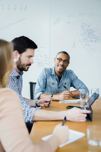 Coworkers using digital tablet in board room