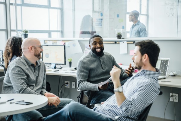 Men smiling during meeting in office