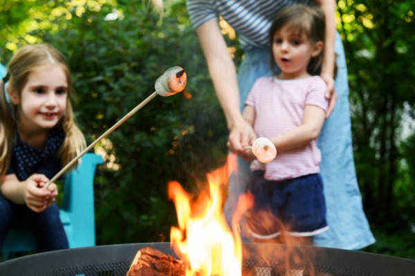 Family toasting marshmallows over brazier