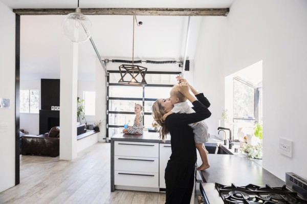 Mother holding son on kitchen counter