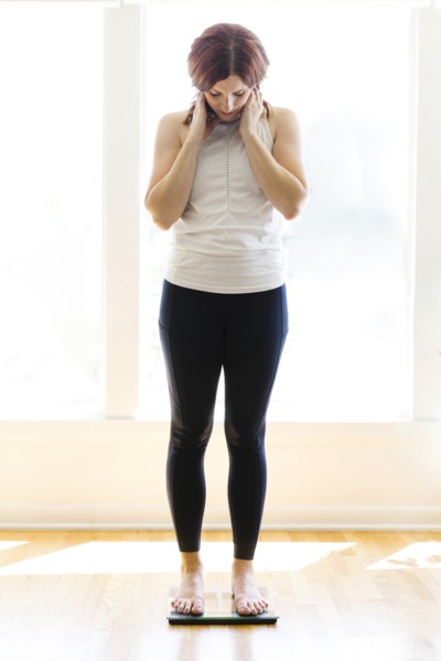 Mid adult woman weighing herself