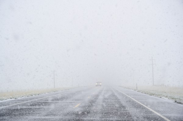 View through windscreen of car on highway during snow