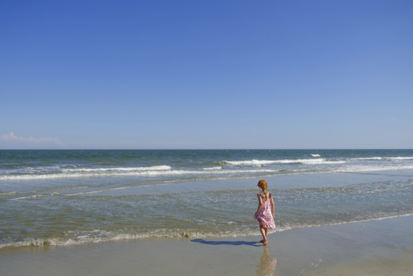 Rear view of girl walking on beach