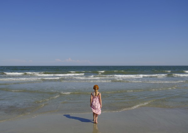 Rear view of girl walking on beach