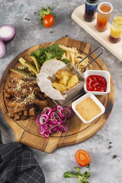 Snacks on cutting board by paddle of shots