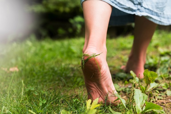 Woman walking barefoot on grass