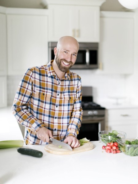 Smiling man chopping vegetables in kitchen
