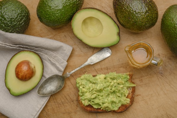Avocado on toast with spoon and oil