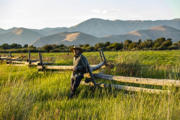 Farmer leaning on fence in Picabo, Idaho, USA