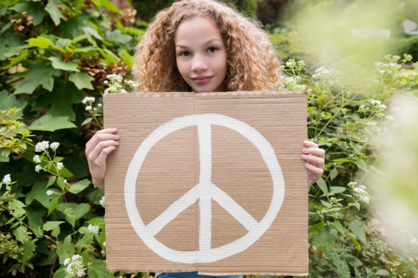 Girl holding sign with peace symbol