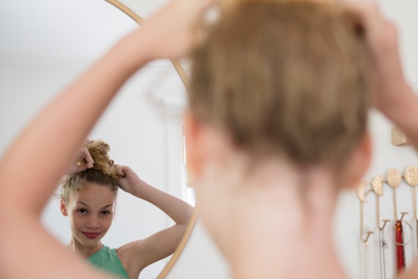 Girl doing hair in mirror
