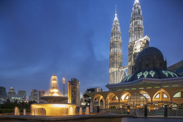 Petronas Towers behind mosque at night in Kuala Lumpur, Malaysia