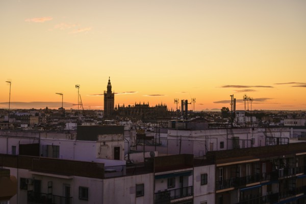 Cityscape with Giralda bell tower at sunset in Seville, Spain