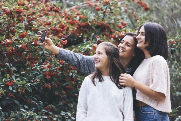 Mother and daughters smiling and taking selfie