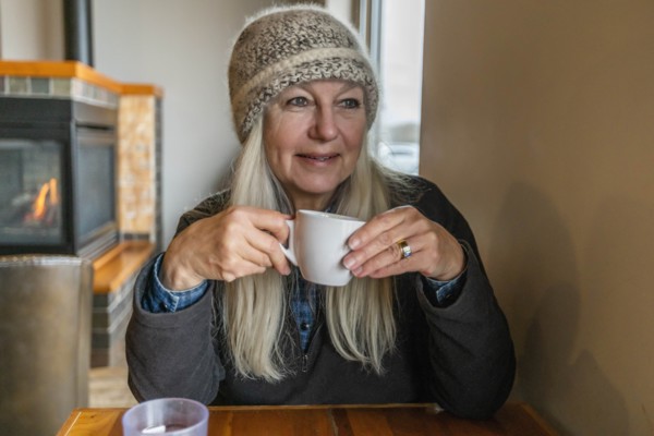 Woman wearing winter clothing holding cup