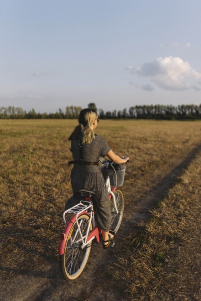 Woman riding bicycle in field