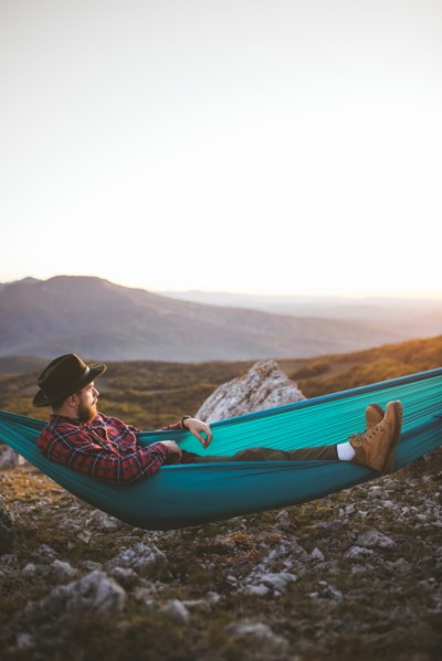 Man lying on hammock in mountain range