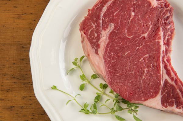 Raw steak and oregano on plate