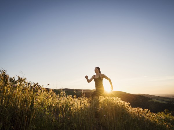 Mid adult woman jogging at sunset