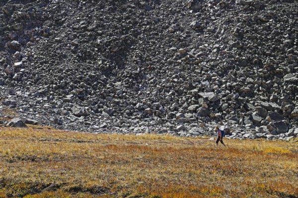 Woman hiking by talus slope in Mayflower Gulch, Colorado