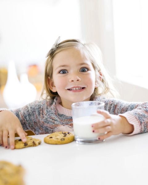 Girl eating milk and cookies