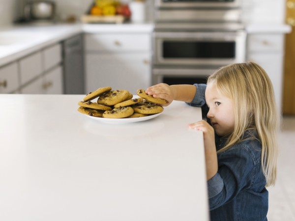 Girl stealing chocolate chip cookie