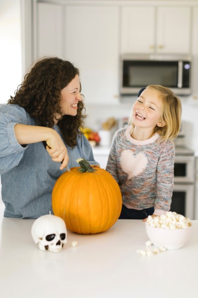 Mother and daughter carving pumpkin for Halloween