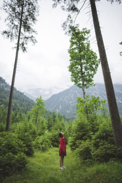 young woman with red jacket in forest