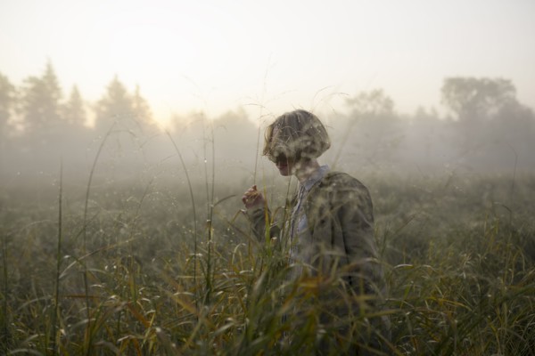 young woman in field of long grass