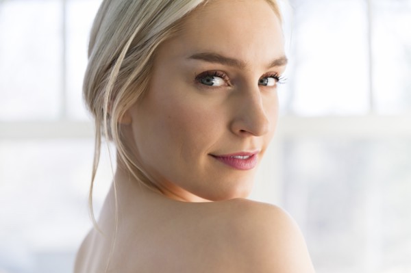 Portrait of woman looking over her bare shoulder
