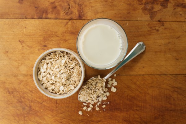Oats and oat milk against wood