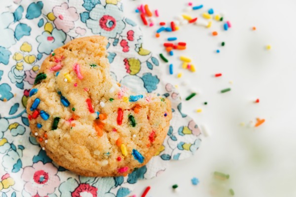 Homemade cookie with colorful sprinkle on floral napkin