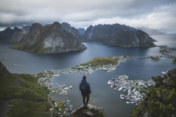 Norway, Lofoten Islands, Reine, Man looking at fjord from Reinebringen mountain