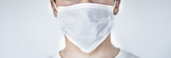 Studio shot of teenage boy (16-17) wearing protective mask