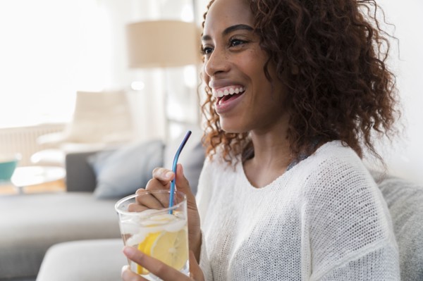 Smiling woman holding drink with straw