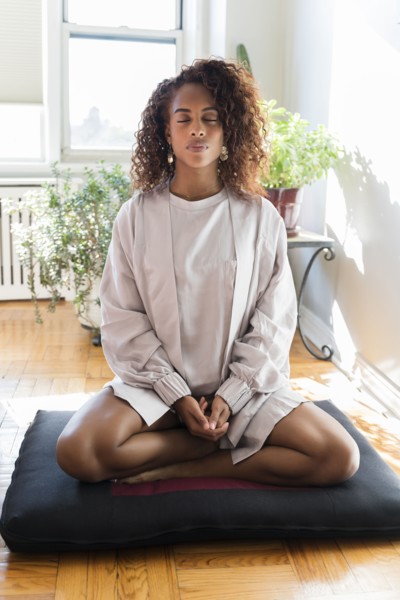 Woman meditating on cushion