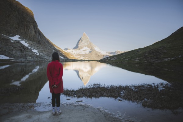 Woman standing by Matterhorn mountain and lake in Valais, Switzerland