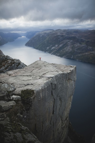 Person standing on Preikestolen cliff in Rogaland, Norway