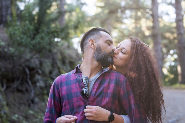 Couple kissing by trees