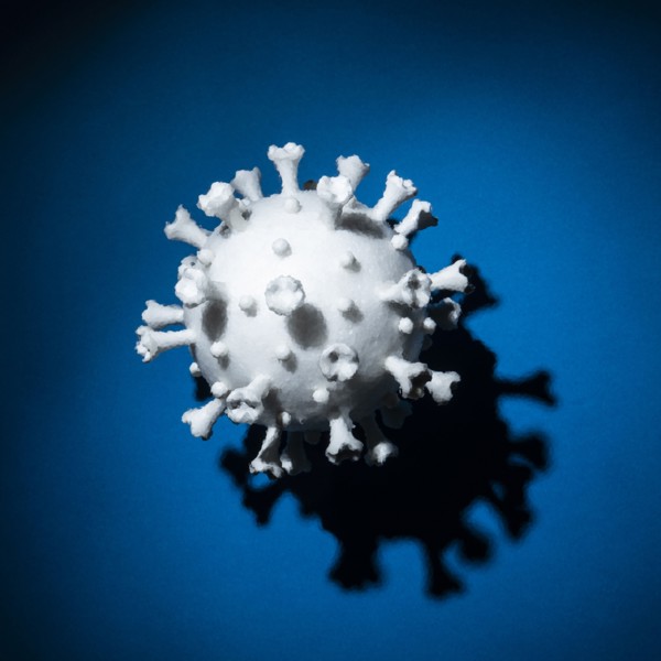 Model of white Coronavirus against blue background