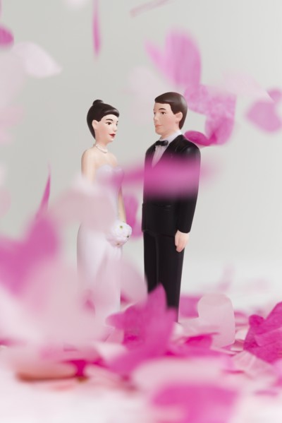 Bride and Groom cake toppers among confetti falling