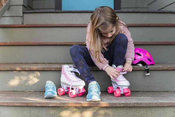 Little girl putting on roller skates