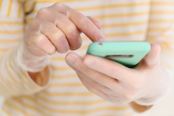 Hands in gloves using smart phone