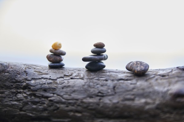 USA, Washington, San Juan County, Orcas Island, Stacks of pebbles on log