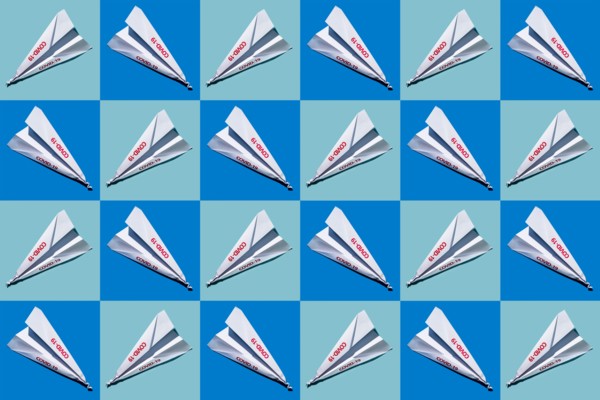 Studio shot of paper planes with Covid-19 sign