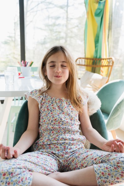 Girl (6-7) meditating at home