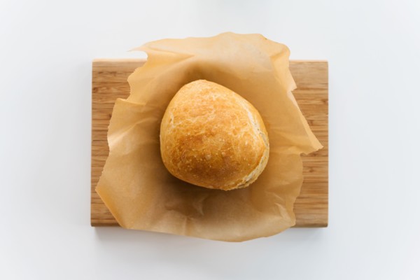 Fresh loaf of bread cooling on cutting board