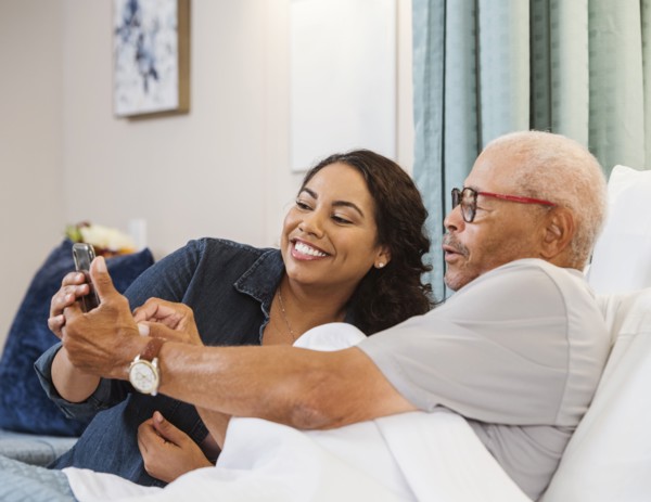 Father and daughter taking selfie in nursing home