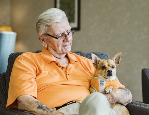 Senior man holding service dog