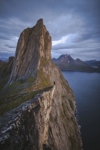 Norway, Senja, Man standing on cliff edge near Segla mountain